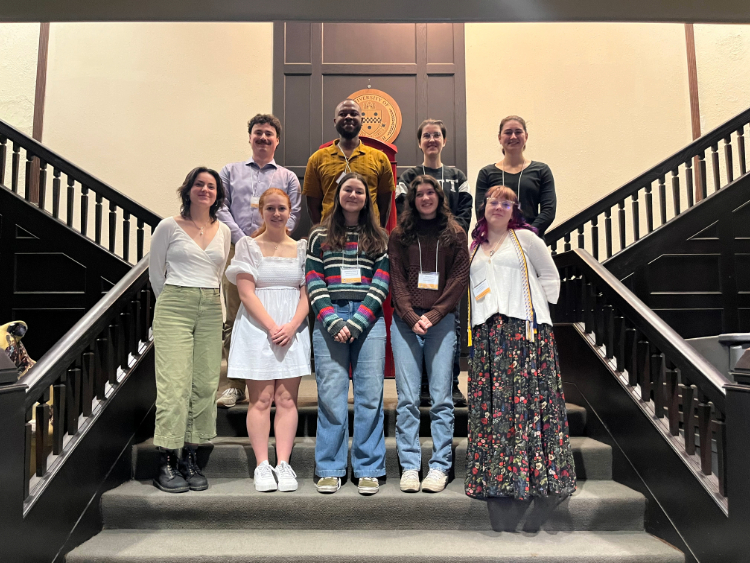 Students pose for a picture on a staircase.