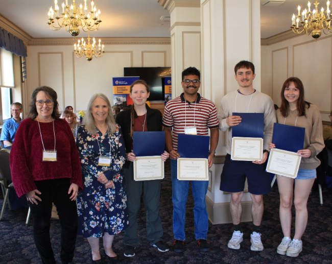 Faculty members stand next to student award recipients.