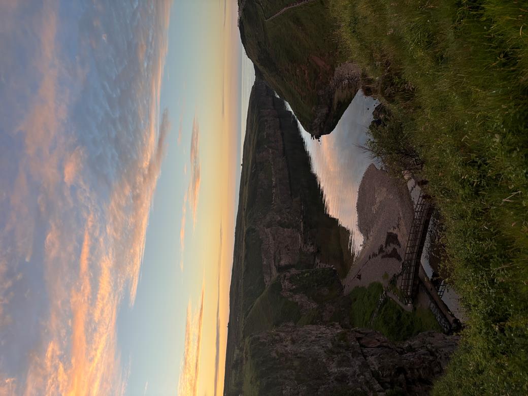 Scottish Higlands landscape of hills overlooking a river flowing into the ocean.