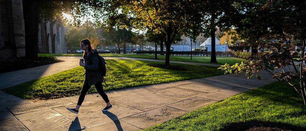 Student crossing the street in the fall